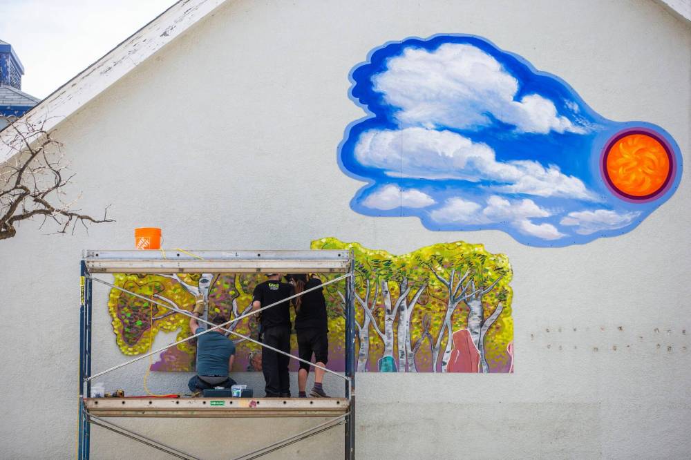 MIKAELA MACKENZIE / WINNIPEG FREE PRESS
Charlie Johnston (left), Brad Lent, and Jeannie White Bird install large mural on east side of Harrow United Church in Winnipeg on Wednesday, May 3, 2023. For Brenda Suderman story. Winnipeg Free Press 2023.