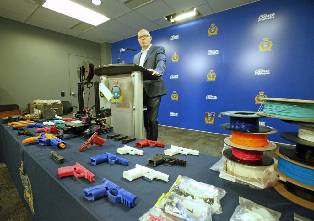 ERIK PINDERA / WINNIPEG FREE PRESS
Insp. Elton Hall behind a display of 3D-printed gun receivers and parts seized by Winnipeg police from an alleged manufacturer on March 31.