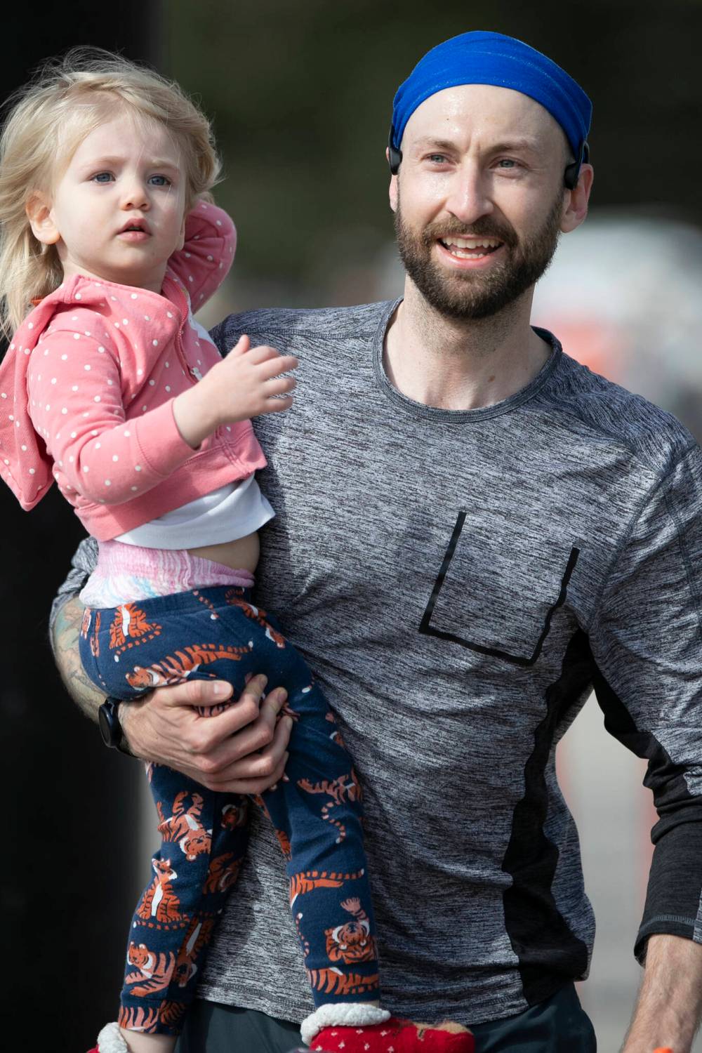 BROOK JONES / WINNIPEG FREE PRESS
                                A marathon participant crosses the finish line, while holding a youngster at the event.
