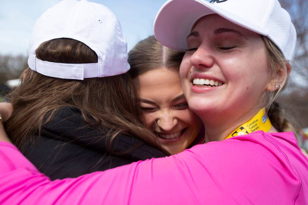 BROOK JONES / WINNIPEG FREE PRESS
                                Marathon runner Kristen Masklyk (right), who has a knee injury, receives hugs from her friends Carlie Bell and Logan Mask after she finished the marathon.