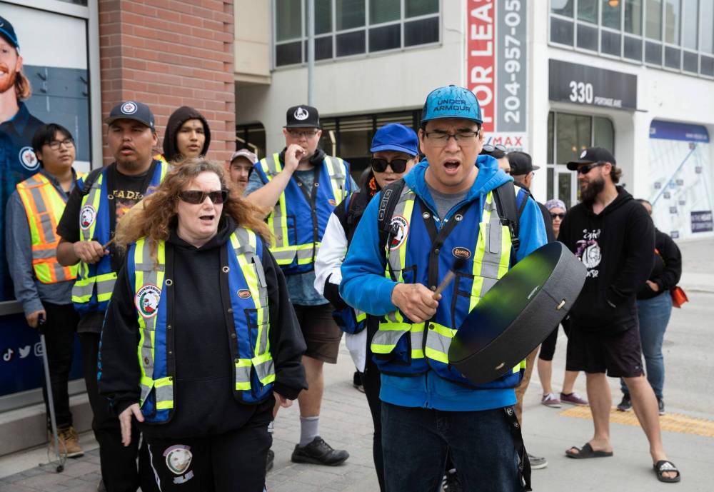JESSICA LEE / WINNIPEG FREE PRESS
Jeje (left) and Johnny Bighetti are part of Thunderbirdz, a community patrol group, that patrolled the downtown core after the event concluded.
