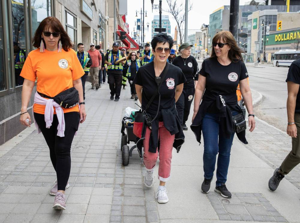 JESSICA LEE / WINNIPEG FREE PRESS
Cindy Porsche (from left), Brenda Jones and Bonnie Leslie walk with their patrol group along Portage Avenue, handing out water and snacks.