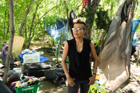 Kathy Smith takes a break from cleaning up the surroundings of her home inside an encampment along the Red River near Waterfront Drive. (Mike Sudoma / Winnipeg Free Press)