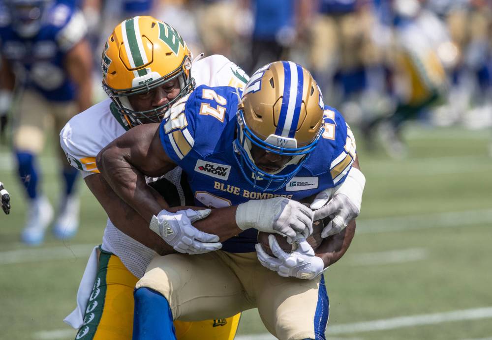 JASON FRANSON / THE CANADIAN PRESS
Winnipeg Blue Bombers’ Johnny Augustine (27) is tackled by Edmonton Elks’ Kony Ealy (90) during the first half.