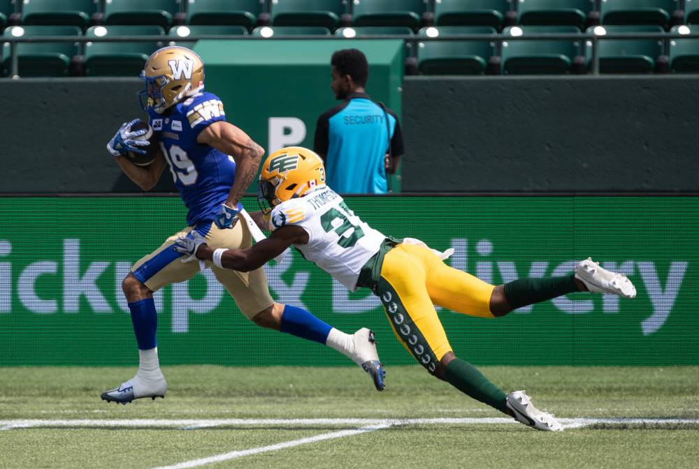 Jason Franson / THE CANADIAN PRESS
Bombers receiver Kenny Lawler breaks free from a tackle by Edmonton Elks’ Dwayne Thompson II Saturday during a CFL exhibition game in Edmonton.