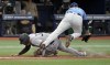 New York Yankees' Aaron Hicks, left, upends Tampa Bay Rays relief pitcher Garrett Cleavinger during a run down between home plate and third base during the tenth inning of a baseball game, Sunday, May 7, 2023, in St. Petersburg, Fla. (AP Photo/Steve Nesius)