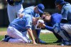 Kansas City Royals starting pitcher Ryan Yarbrough, front left, is tended to by training staff and Royals manager Matt Quatraro, top, after being hit by a ball off the bat of the Oakland Athletics' Ryan Noda during the sixth inning of a baseball game, Sunday, May 7, 2023, in Kansas City, Mo. (AP Photo/Reed Hoffmann)