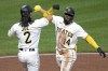 Pittsburgh Pirates' Rodolfo Castro (14) celebrates with Connor Joe after as he crosses home plate after hitting a two-run home run off Colorado Rockies starting pitcher Kyle Freehand during the seventh inning of a baseball game in Pittsburgh, Monday, May 8, 2023. (AP Photo/Gene J. Puskar)