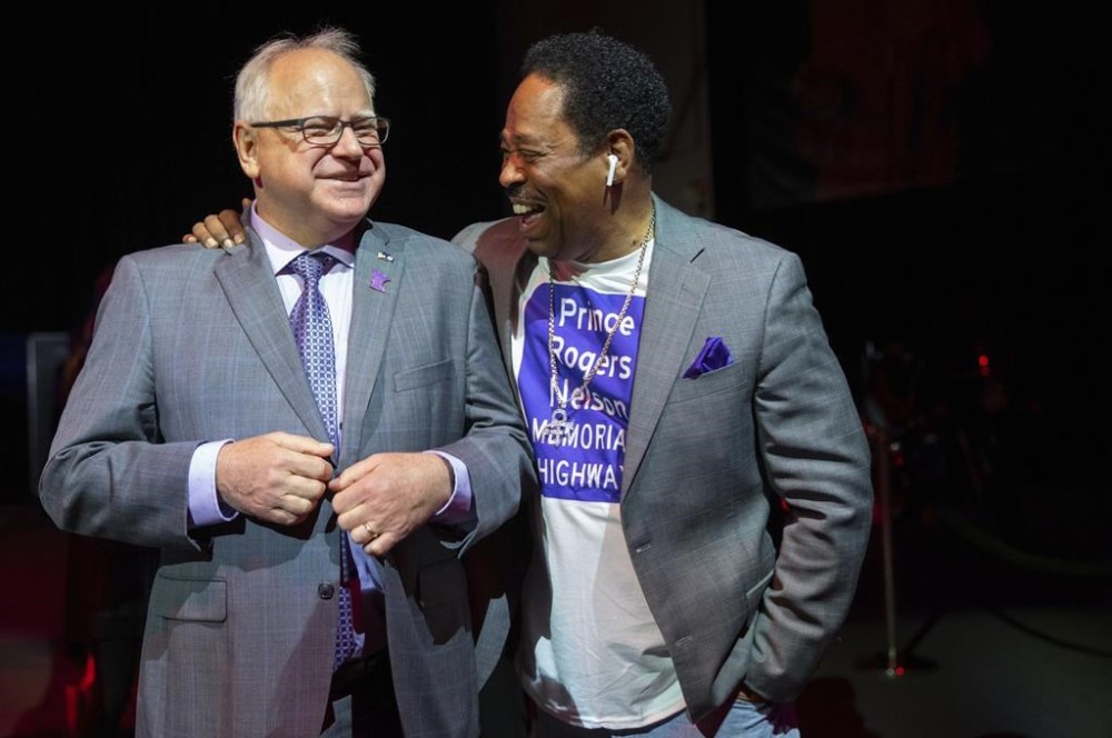 Minnesota Gov. Tim Walz and Mark Webster, a major advocate for the bill, share a laugh before the bill signing ceremony renaming a 7-mile stretch of Highway 5 as