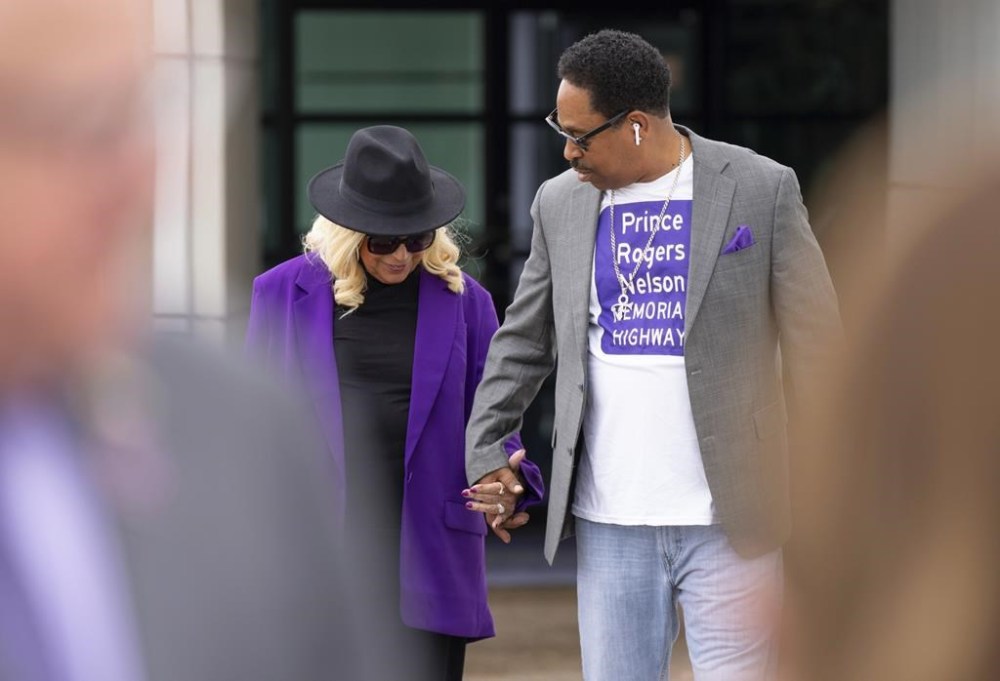 Sharon Nelson, Prince's sister, holds hands with Mark Webster, a major advocate for the bill, before Minnesota Gov. Tim Walz signed a bill renaming a 7-mile stretch of Highway 5 as