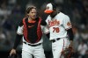 Baltimore Orioles catcher Adley Rutschman, left, and relief pitcher Yennier Cano react after pitching to the Tampa Bay Rays during the seventh inning of a baseball game, Tuesday, May 9, 2023, in Baltimore. The Orioles won 4-2. (AP Photo/Julio Cortez)