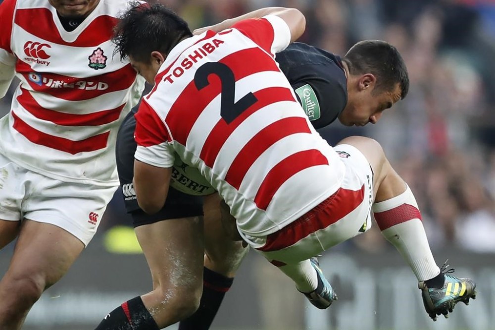 FILE - Japan's Atsushi Sakate, front, tackles England's Alex Lozowski during their rugby union international match at Twickenham stadium in London, Nov. 17, 2018. Sakate believes the improved standard of the Japanese professional league will help the Brave Blossoms' preparation for the Rugby World Cup in France later this year. (AP Photo/Alastair Grant, File)