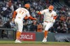 San Francisco Giants third base coach Mark Hallberg (91) congratulates Casey Schmitt (6) on his solo home run off Washington Nationals starting pitcher Patrick Corbin during the fourth inning of a baseball game Tuesday, May 9, 2023, in San Francisco. (Ray Chavez/Bay Area News Group via AP)