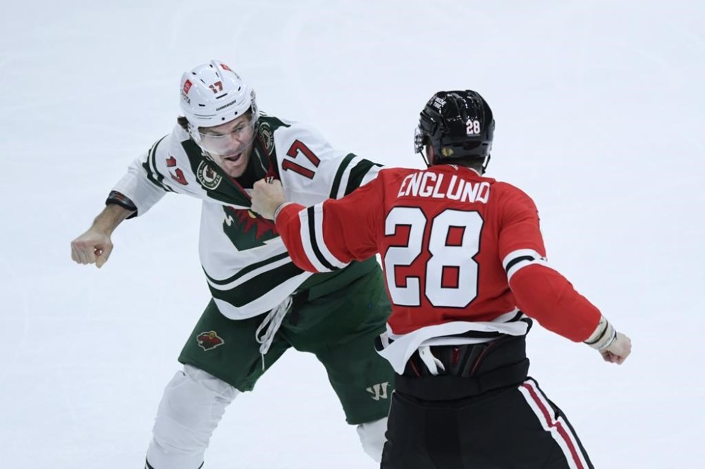 Minnesota Wild's Marcus Foligno (17) fights Chicago Blackhawks' Andreas Englund (28) during the third period of an NHL hockey game Monday, April 10, 2023, in Chicago. A study looking at National Hockey League players who spend more time dropping the gloves or in the penalty box tend to live 10 years less than their peers. THE CANADIAN PRESS/AP/Paul Beaty