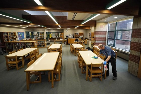 Custodian David Bishop cleans pencil marks from desks in the Hampden Academy library in Hampden, Maine. (Robert F. Bukaty / The Associated Press)