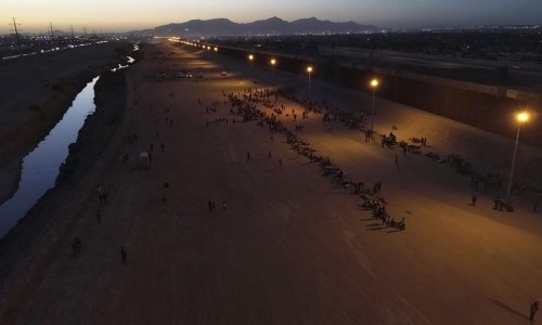 Migrants wait for U.S. authorities, between a barbed-wire barrier and the border fence at the US-Mexico border, as seen from Ciudad Juarez, Mexico, Wednesday, May 10, 2023. THE CANADIAN PRESS/AP-Christian Chavez