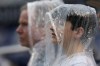 Fans wear rain ponchos during the first inning of a baseball game between the Washington Nationals and the New York Mets at Nationals Park, Saturday, May 13, 2023, in Washington. (AP Photo/Alex Brandon)