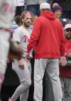 Philadelphia Phillies' Bryce Harper, left, is prompted back to the dugout after reacting to a taunt toward the Phillies' dugout by Colorado Rockies relief pitcher Jake Bird after the top of the seventh inning of a baseball game Sunday, May 14, 2023, in Denver. (AP Photo/David Zalubowski)