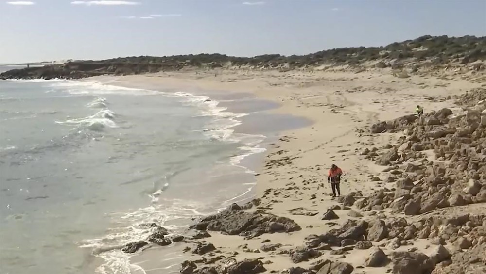 In this image from a video, searchers conduct an operation along a coastline in Elliston, Australia Saturday, May 13, 2023. Police continued to search Monday for remains of a 46-year-old surfer who was attacked by a shark off the south Australian coast two days earlier. (Australian Broadcasting Corp. via AP)