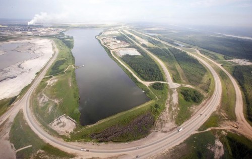 The Alberta Energy Regulator says a total of 32 dead waterfowl have been found at two separate oilsands tailings ponds operated by Suncor Energy Inc. A highway loops around a tailings pond at the Syncrude facility as seen from a helicopter tour of the oil sands near Fort McMurray, Alta., on July 10, 2012. THE CANADIAN PRESS/Jeff McIntosh