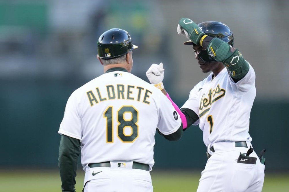 Oakland Athletics' Esteury Ruiz, right, celebrates with first base coach Mike Aldrete after hitting an RBI single against the Arizona Diamondbacks during the third inning of a baseball game in Oakland, Calif., Monday, May 15, 2023. (AP Photo/Godofredo A. Vásquez)
