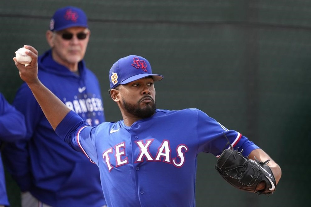 FILE - Texas Rangers manager Bruce Bochy watches while pitcher Kumar Rocker throws during baseball spring training Feb. 17, 2023, in Surprise, Ariz. Rocker, a top 10 pick in each of the past two MLB drafts, has a torn ligament in his right elbow that will need Tommy John surgery. Rangers general manager Chris Young said Tuesday, May 16, that Rocker had an MRI after coming out in the fifth inning of his last start for Class-A Hickory. The surgery will probably be later this week. (AP Photo/Charlie Riedel, File)