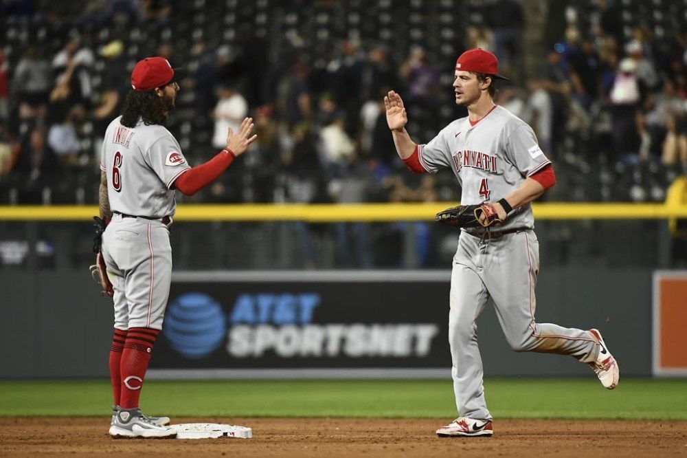 Cincinnati Reds second baseman Jonathan India and right fielder Wil Meyers celebrate a 3-1 win against the Colorado Rockies in a baseball game Tuesday, May 16, 2023, in Denver. (AP Photo/Geneva Heffernan)