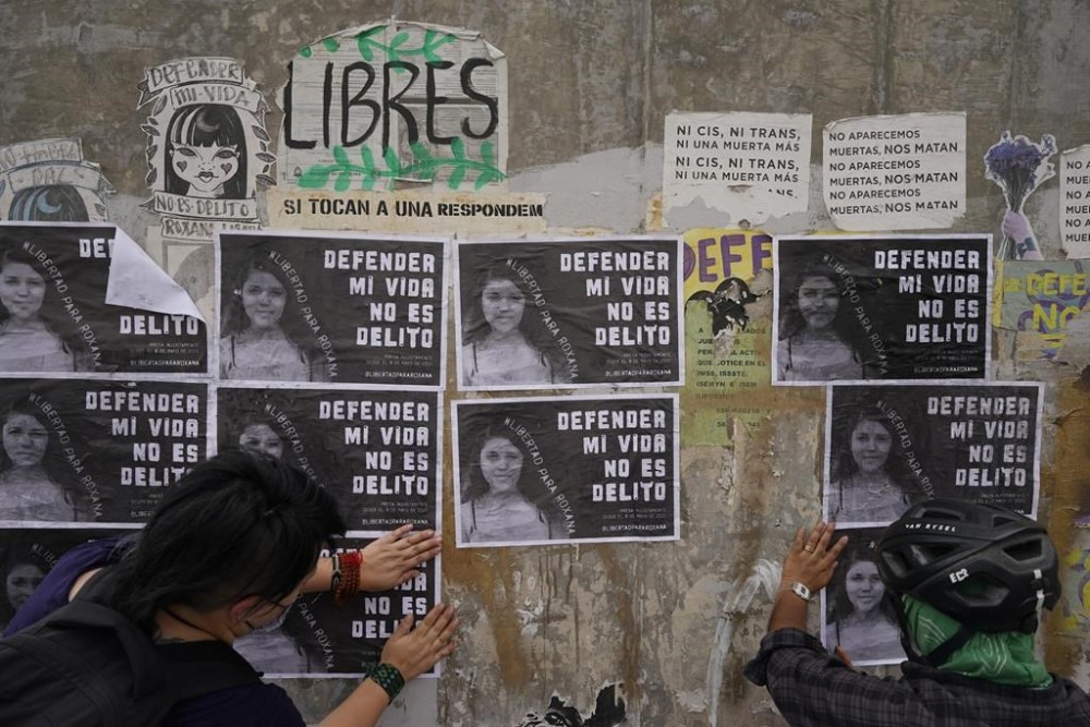 FILE - Activists paste photos of Roxana Ruiz that read in Spanish