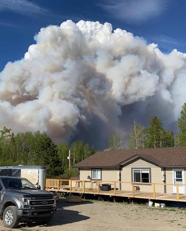 Smoke from a fire billows over the home of Kody Crook and Toni Chittim north of Fort St. John, B.C. The house was unscathed by the fire, as were five horses on the property, Chittim said.THE CANADIAN PRESS/HO-Kody Crook and Toni Chittim *MANDATORY CREDIT*