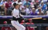 Colorado Rockies' Brenton Doyle follows the flight of his triple to drive in two runs off Cincinnati Reds relief pitcher Lucas Sims in the sixth inning of a baseball game Wednesday, May 17, 2023, in Denver. (AP Photo/David Zalubowski)