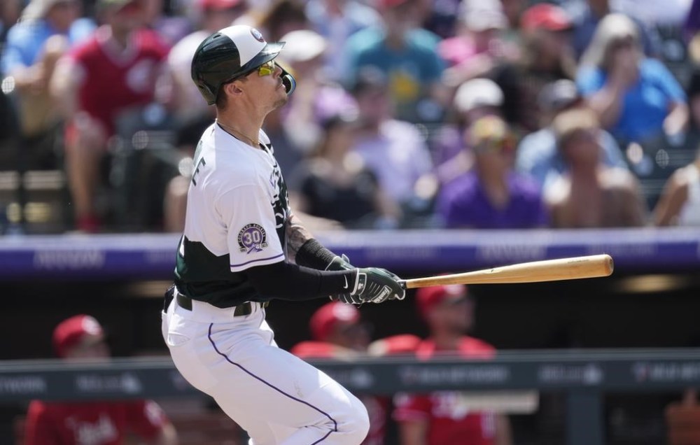 Colorado Rockies' Brenton Doyle follows the flight of his triple to drive in two runs off Cincinnati Reds relief pitcher Lucas Sims in the sixth inning of a baseball game Wednesday, May 17, 2023, in Denver. (AP Photo/David Zalubowski)