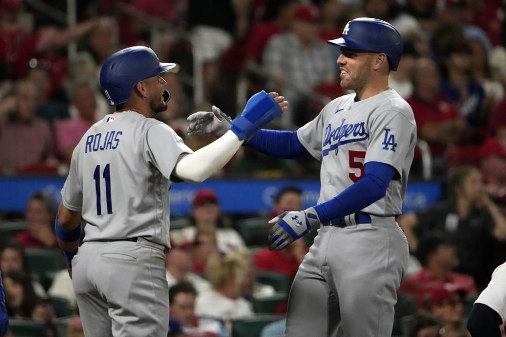 Los Angeles Dodgers' Freddie Freeman (5) gets a hug from teammate Miguel Rojas (11) after hitting a grand slam during the sixth inning of a baseball game against the St. Louis Cardinals Thursday, May 18, 2023, in St. Louis. (AP Photo/Jeff Roberson)
