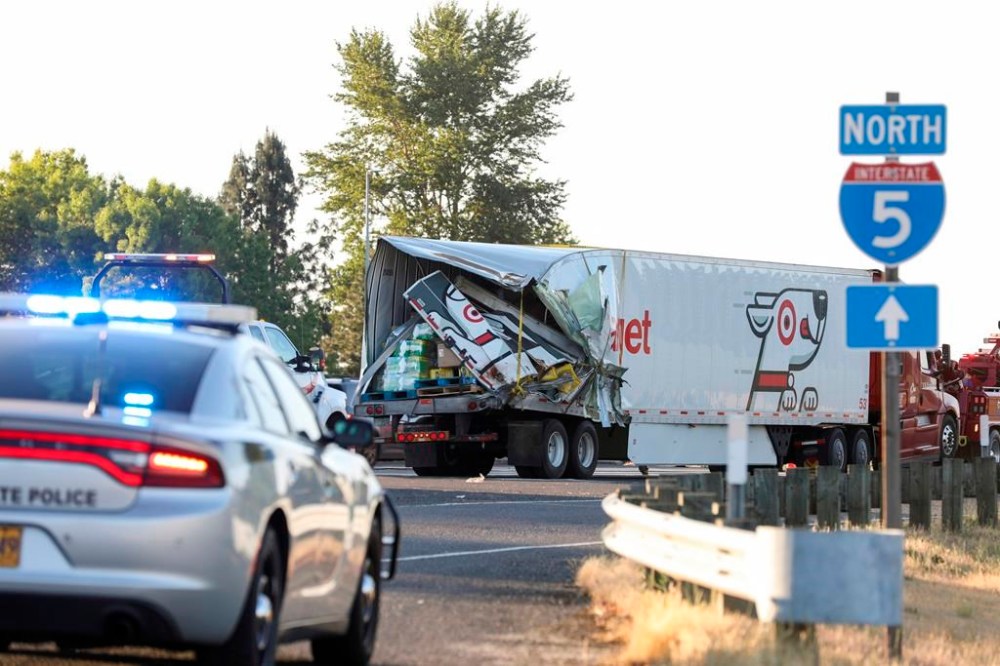 The back end of a semi-truck sits along Interstate 5, on Thursday, May 18, 2023, in Marion County, Ore. Two semi-trucks and a passenger van were involved a deadly crash, which occurred near the city of Albany in an agricultural area of western Oregon, state police said on Thursday. (Abigail Dollins/Statesman Journal via AP)