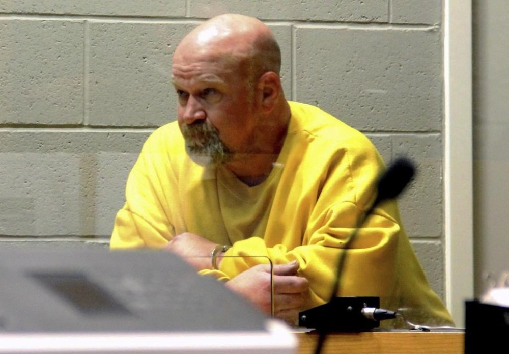 Lincoln Clayton Smith, 52, of North Highlands, Calif. looks at the judge through the glass as he is being arraigned at the Marion County Court Annex on Friday, May 19, 2023. in Salem, Ore. Prosecutors say Smith was under the influence of a controlled substance when he drove his semi-truck into a van filled with 11 passengers that was parked on the side of Interstate 5 near Albany, Oregon on Thursday, killing seven adults and injuring four more. (Bill Poehler/Statesman-Journal via AP)