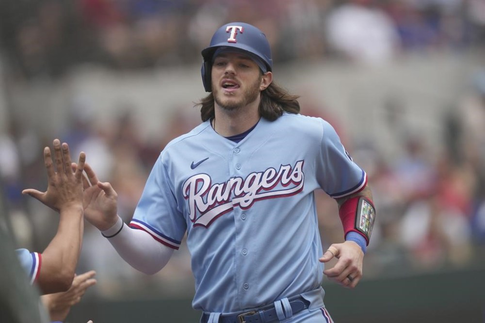 Texas Rangers Jonah Heim is congratulated after scoring on a double by fielder Leody Taveras during the fifth inning of a baseball game against the Colorado Rockies in Arlington, Texas, Sunday, May 21, 2023. (AP Photo/LM Otero)