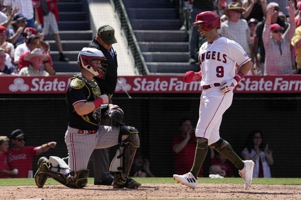 Los Angeles Angels' Zach Neto, right, scores on a double by Mickey Moniak on as Minnesota Twins catcher Ryan Jeffers kneels at the plate during the seventh inning of a baseball game Sunday, May 21, 2023, in Anaheim, Calif. (AP Photo/Mark J. Terrill)