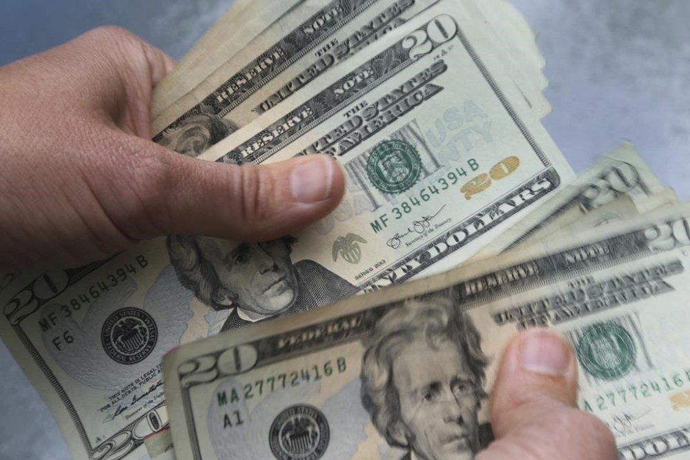 FILE - In this June 15, 2018 photo, twenty dollar bills are counted in North Andover, Mass. As the middle of the year approaches, it’s a smart time to check in on the money goals you set back in January and make any necessary adjustments. If you didn’t create goals, it’s not too late to establish them for the second half of the year. First, define or update what your goals are. (AP Photo/Elise Amendola, File)