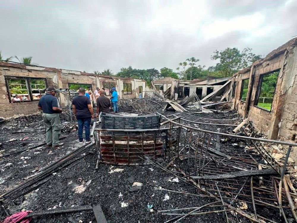 In this photo provided by Guyana's Department of Public Information, the dormitory of a secondary school is burned in Mahdia, Guyana, Monday, May 22, 2023. A nighttime fire raced through the dormitory early Monday, killing at least 20 students and injuring several others, authorities said. (Guyana's Department of Public Information via AP Photo)