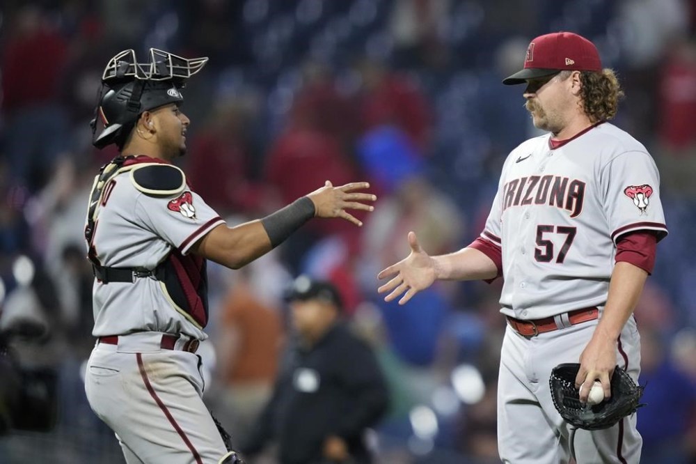 Arizona Diamondbacks' Gabriel Moreno, left, and Andrew Chafin celebrate after the Diamondbacks won a baseball game against the Philadelphia Phillies, Monday, May 22, 2023, in Philadelphia. (AP Photo/Matt Slocum)