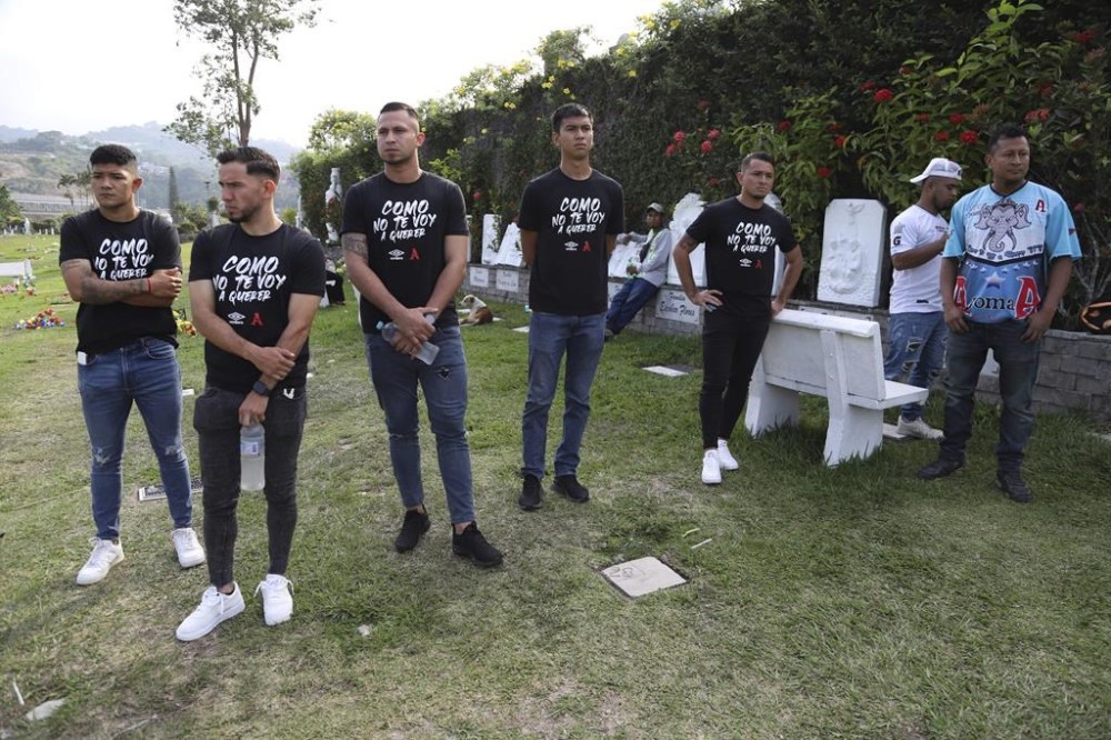 Alianza FC players attend the funeral of Alberto Antonio Palacios, one of the soccer fans that died in the recent Cuscatlan stadium stampede, during his burial at the Jardines del Recuerdo cemetery in San Salvador, El Salvador, Monday, May 22, 2023. The tragedy occurred when stampeding fans pushed through one of the access gates during a quarterfinal Salvadoran league soccer match between Alianza and FAS. Their t-shirts have a phrase that reads in Spanish
