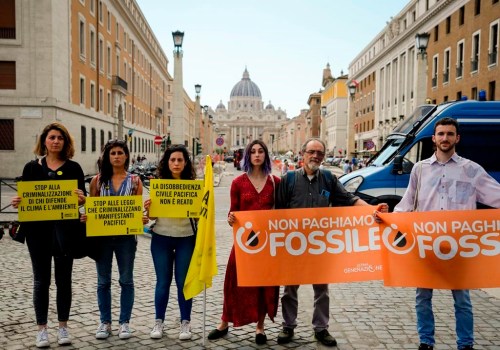 Ultima Generazione (Last Generation) activists Ester Goffi, fourth from left, and Guido Viero, fifth from left, arrive at The Vatican, Wednesday, May 24, 2023, where they are on trial for having staged a protest in August inside the Vatican Museums during which they glued their hands to the base of one of the ancient sculpture, the Laocoon, and face up to three years and 3,000 euros in fines, according to Ultima Generazione. Authorities raided 15 properties across Germany on Wednesday, May 24, 2023 and seized assets in an investigation into the financing of protests by the Last Generation climate activist group, prosecutors said. Banners and placards in Italian urge not to criminalize pacific demonstrators and one reads 