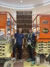 In this photo provided by Landon Aydlett, Brandon Aydlett, left, and Landon Aydlett pose for a photo on June 16, 2022, in front of a partially constructed toy timber tower called a 