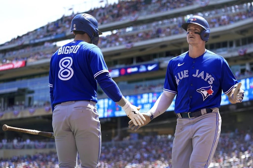 Toronto Blue Jays' Matt Chapman, right, celebrates with Cavan Biggio (8) after scoring during the second inning of a baseball game against the Minnesota Twins, Sunday, May 28, 2023, in Minneapolis. (AP Photo/Abbie Parr)