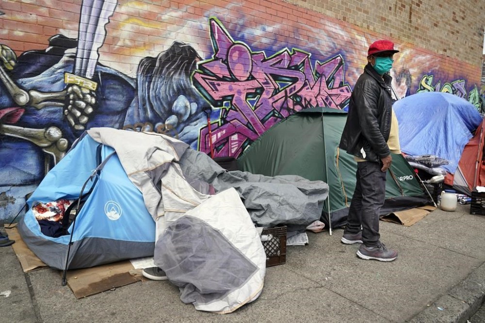 FILE - Sotero Cirilo stands near the tent where he sleeps next to other homeless people in the Queens borough of New York, April 14, 2021. Even as New York Mayor Eric Adams asks a judge to set aside the city's longstanding right to shelter, he quietly allowed a