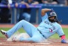Toronto Blue Jays first baseman Vladimir Guerrero Jr. (27) slides into homeplate to score during first inning Interleague MLB baseball action against the Milwaukee Brewers in Toronto on Tuesday, May 30, 2023. THE CANADIAN PRESS/Nathan Denette