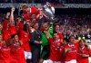 FILE - Manchester United's Gary Neville, second right, his brother Phil Neville, right, and the players celebrate with the trophy after wining the UEFA Champions Cup final, beating Bayern Munich 2-1, at the Nou Camp Stadium in Barcelona, Wednesday, May 26, 1999. Gary Neville says he is in fear ahead of the FA Cup final between Manchester United and Manchester City. He was a part of United’s treble-winning team of 1999 when it became the only English soccer team to win the three major trophies in a single season. (AP Photo/Camay Sungu, File)