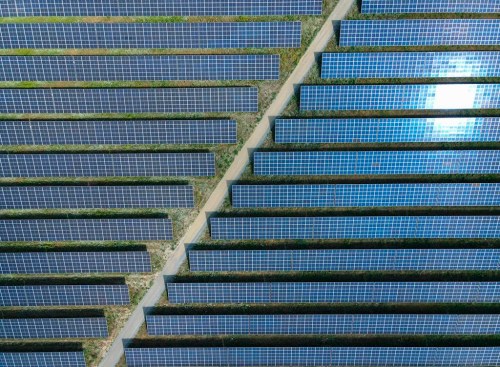 The sun reflected in solar panels of the EnBW solar park at Gottesgabe, Germany, Friday, July 1, 2022. The world is set to add a record amount of renewable electricity capacity this year as governments and consumers seek to offset high energy prices and take advantage of a boom in solar power. (Patrick Pleul/dpa via AP)