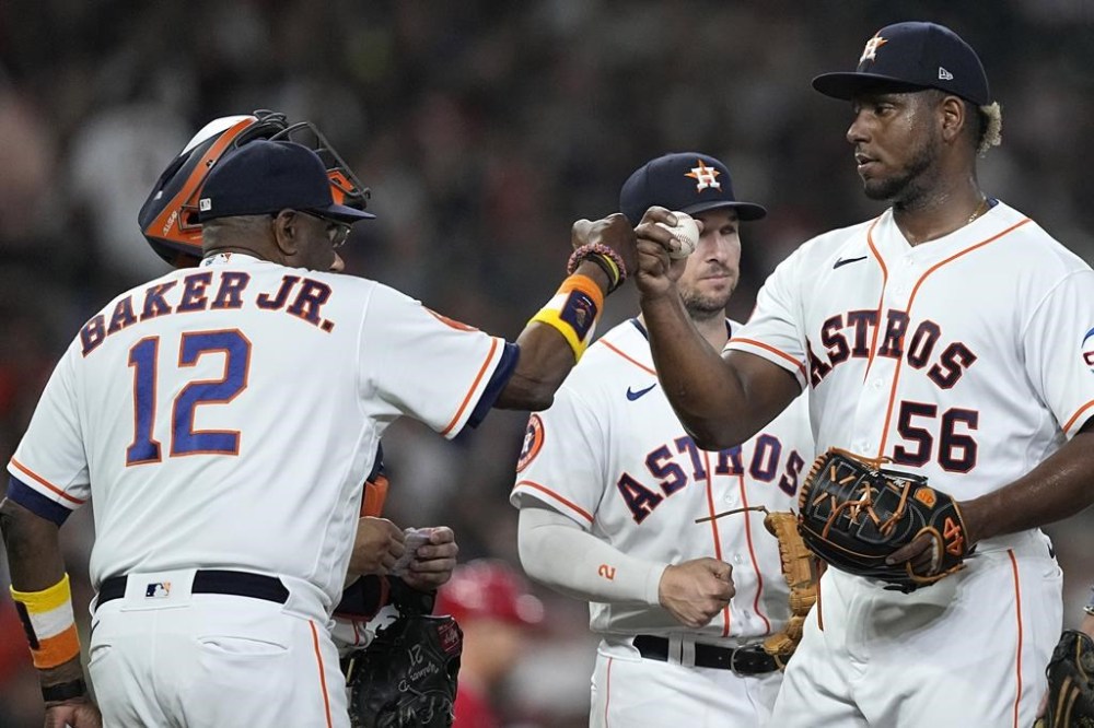 Houston Astros manager Dusty Baker Jr. (12) bumps fists with starting pitcher Ronel Blanco (56) as he pulls him during the sixth inning of a baseball game against the Los Angeles Angels Thursday, June 1, 2023, in Houston. (AP Photo/David J. Phillip)