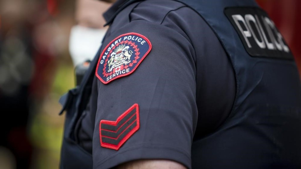 Calgary police say a father and his son have been arrested and charged after multiple teenage girls were sexually exploited, assaulted and extorted for several months. A Calgary Police Service officer is seen in Calgary on April 14, 2020. THE CANADIAN PRESS/Jeff McIntosh