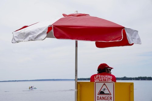 Lifeguards work at Brittany Beach on the Ottawa River in Ottawa on Friday, June 24, 2022. Staff running pools and beaches across Canada are trying to entice people to work as lifeguards amid a shortage, the Lifesaving Society says. THE CANADIAN PRESS/Sean Kilpatrick